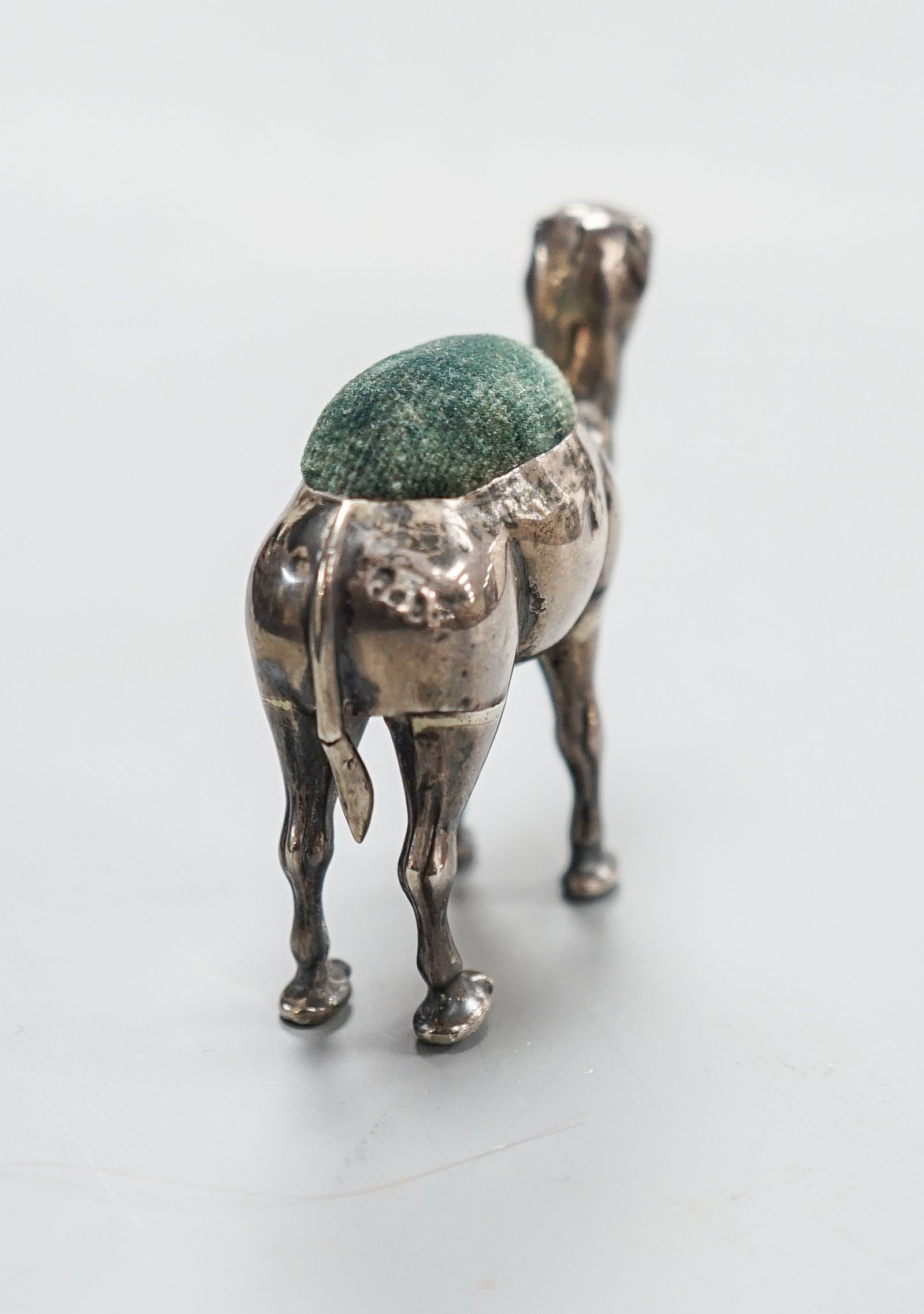 A George V novelty silver mounted pin cushion, modelled as a camel, ?H &S, Birmingham, 1911, height 49mm(a.f).